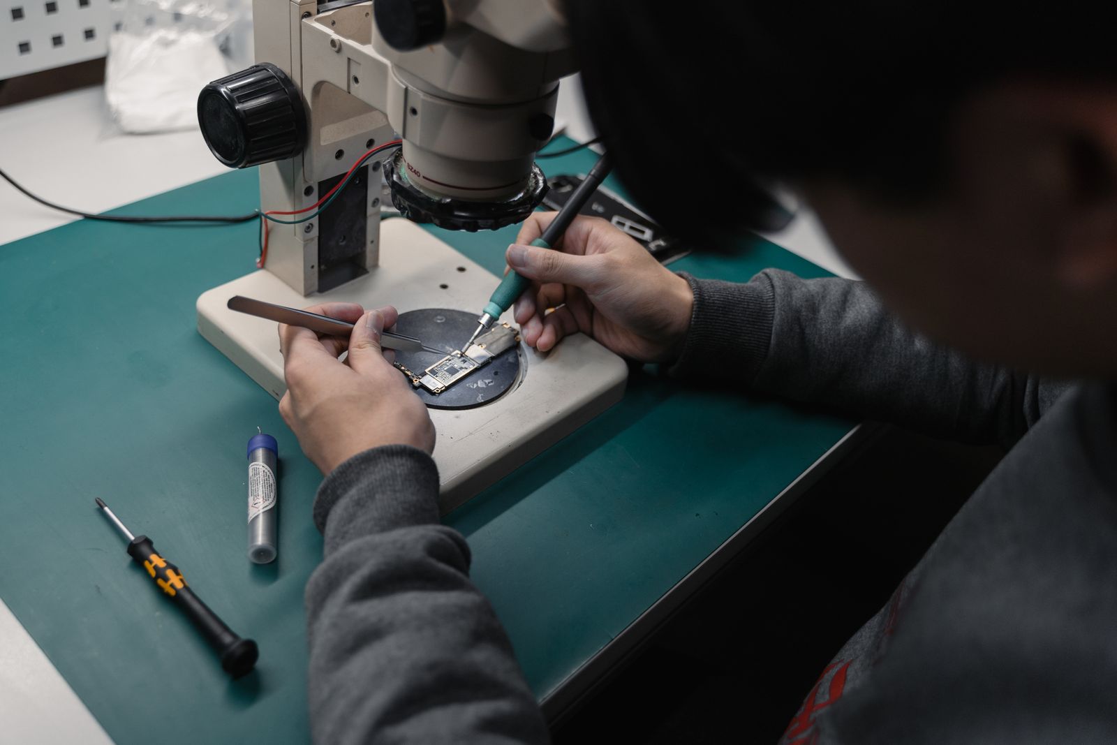 Reparatur einer defekten Platine unter dem Mikroskop